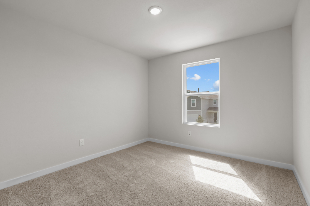 A room with a window and a rug.