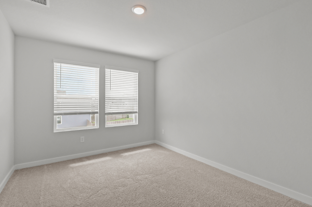 A room with a window and a carpet.