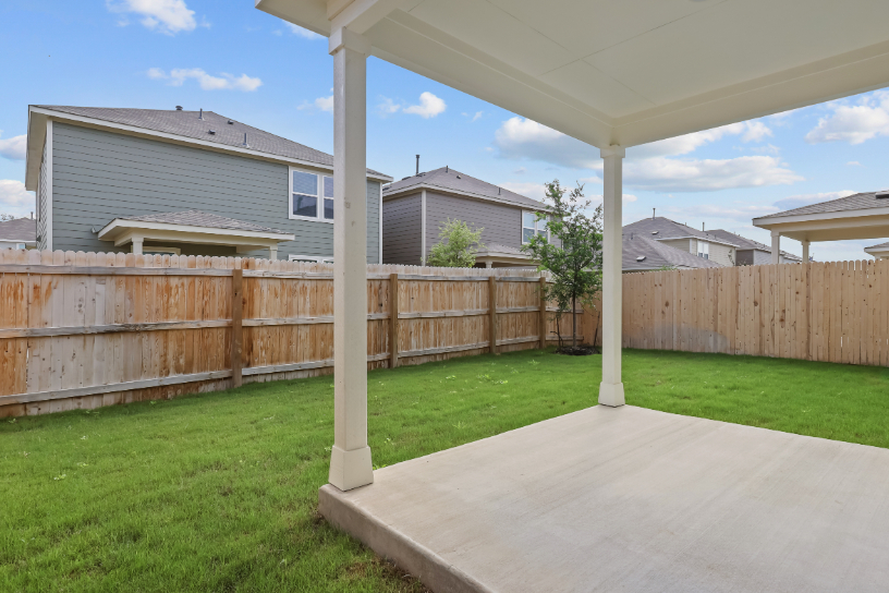 A backyard with a fence and a wood fence.