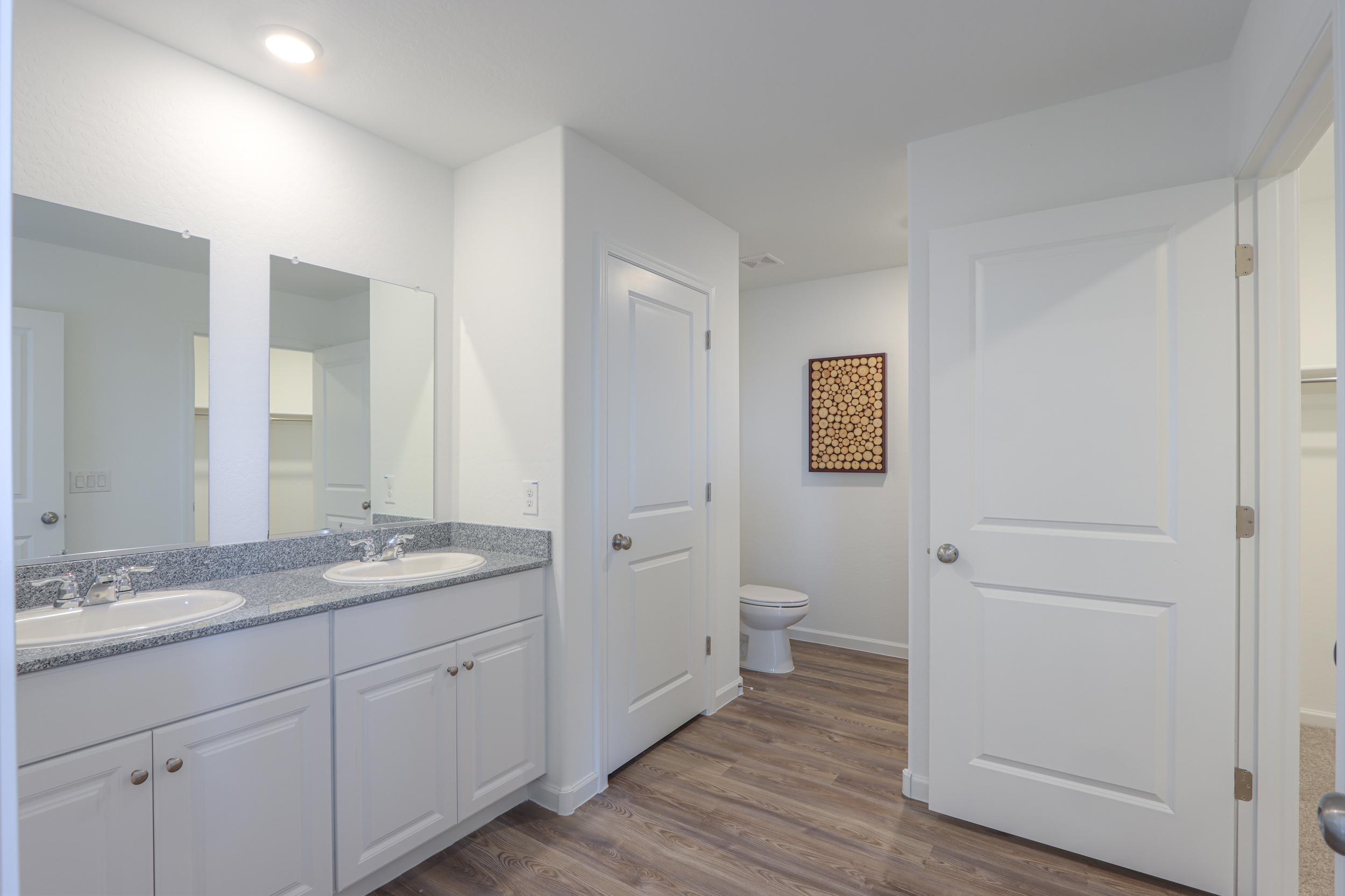 A bathroom with white cabinets.