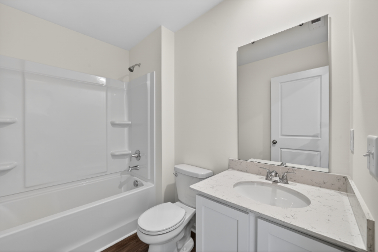 A bathroom with a tub sink and toilet.