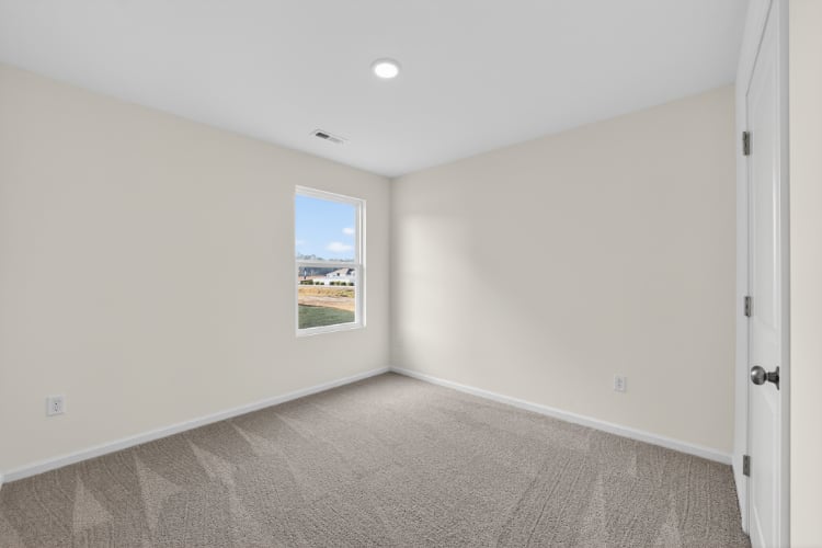 A room with a window and a carpet.