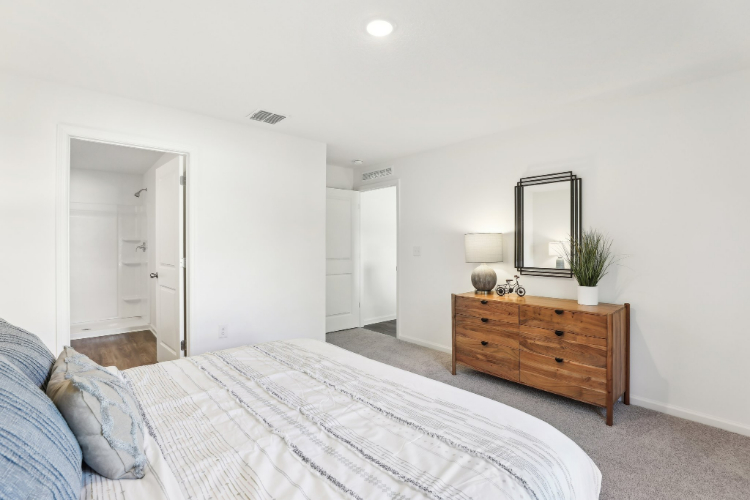 A bedroom with a bed and a dresser.
