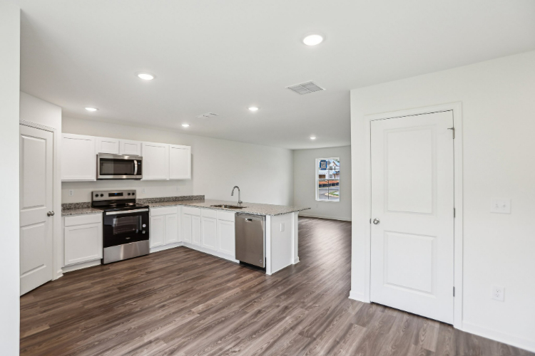 A kitchen with white cabinets.