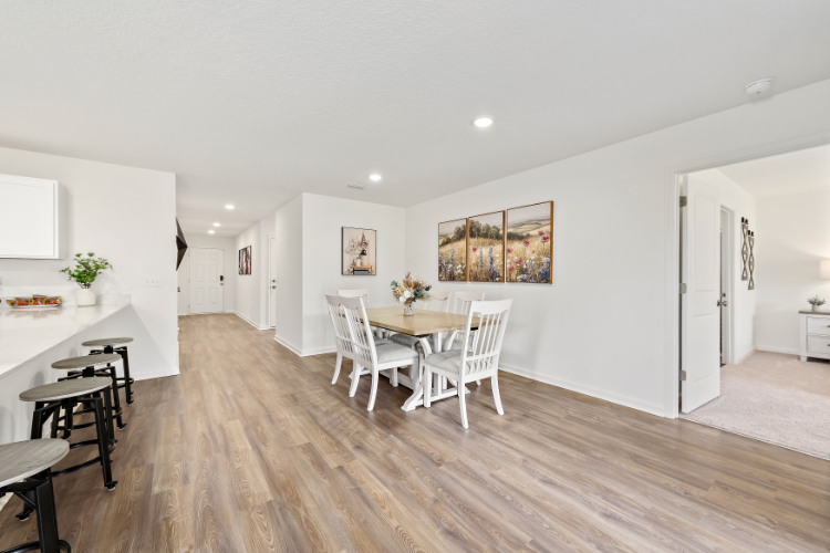 A dining room with a wood floor.