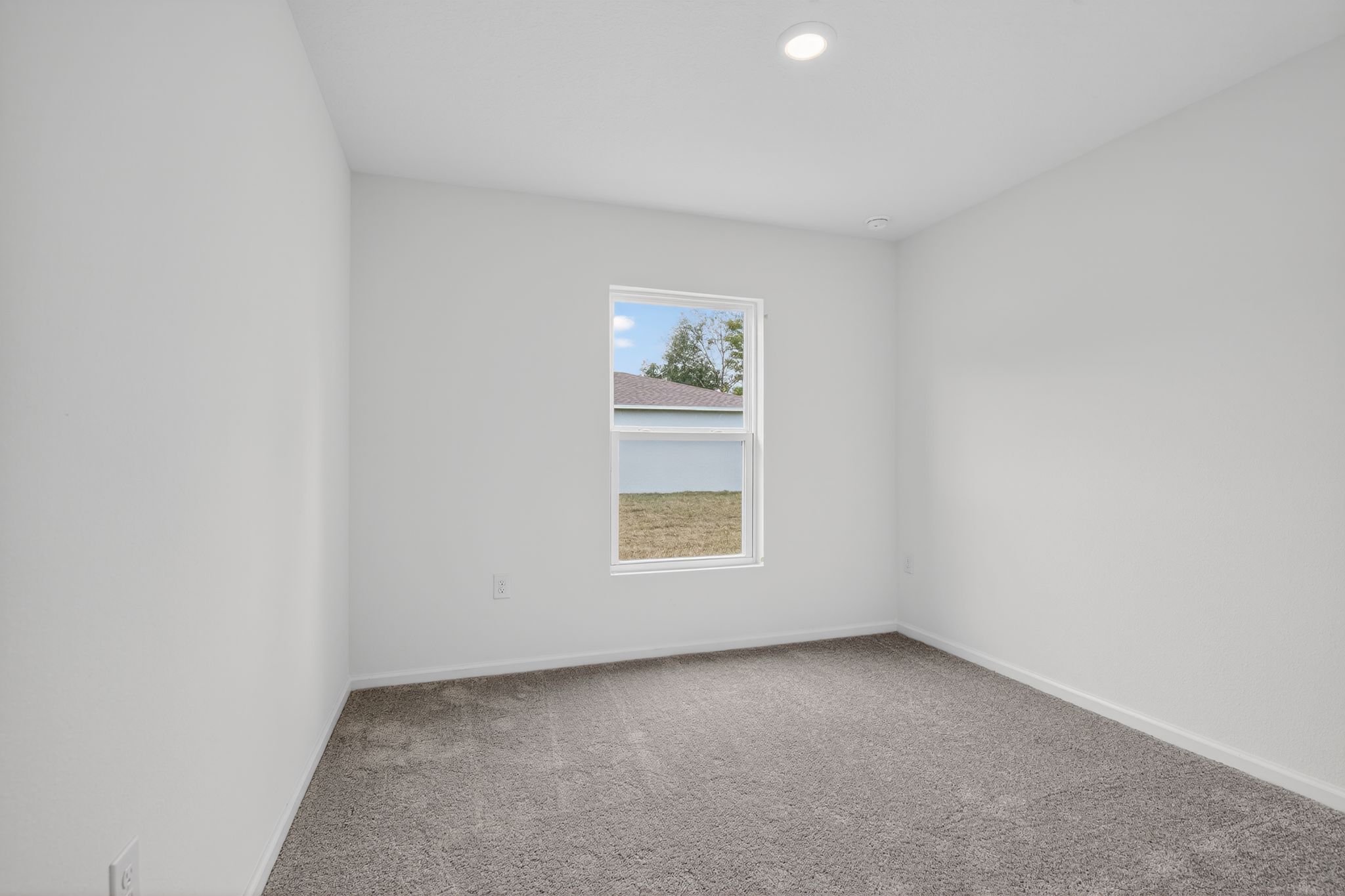 A room with a window and carpet.