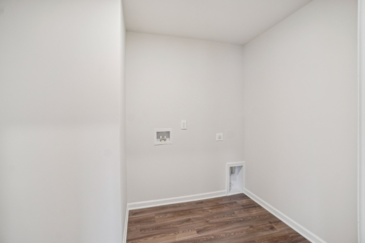 A white room with a wood floor.